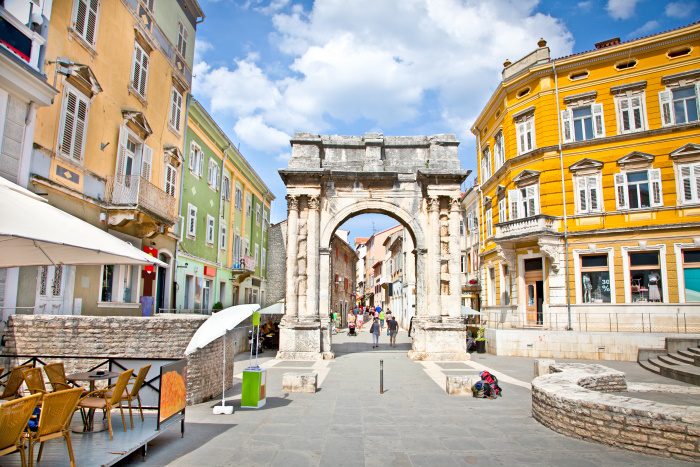 pula street with colourful houses and arch