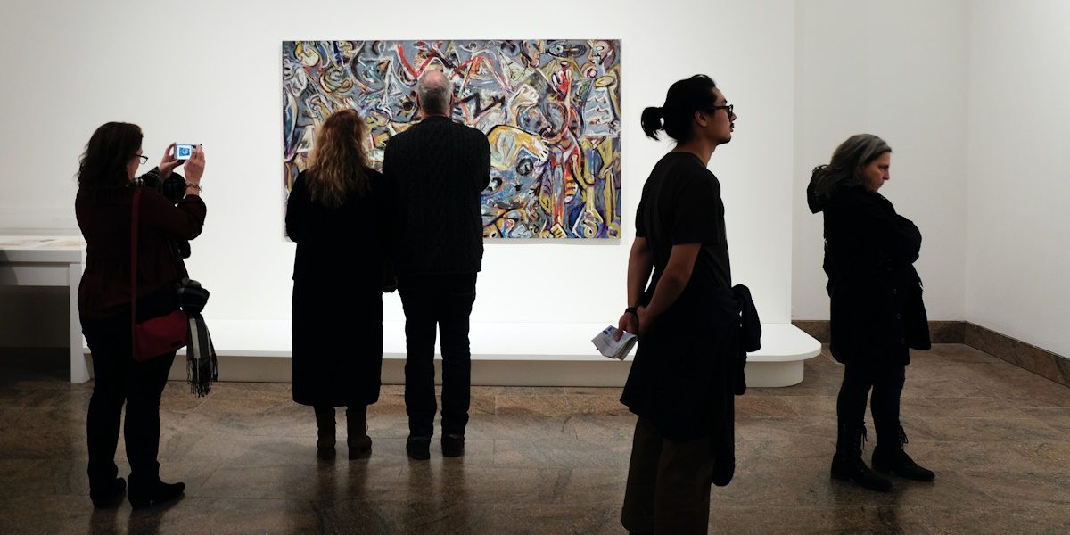 People in a modern art gallery looking at a colourful painting