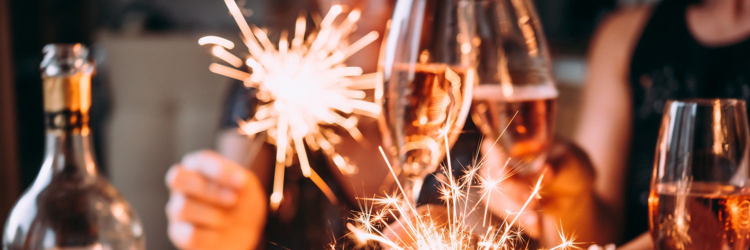 people clinking champagne glasses on new year's eve