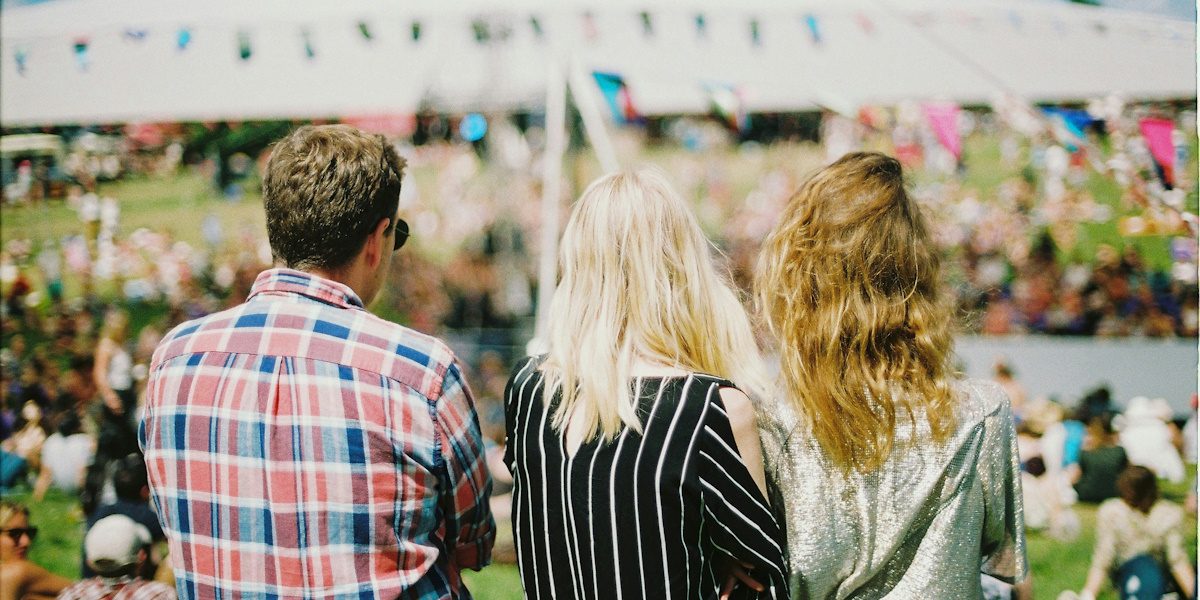 Three people looking across a festival space